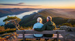© Cliff - Elderly couple in love sitting on a bench on a mountain overlooking a lake, watching the landscape during a romantic trip, view from the back, retirement vacation