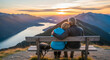 © Cliff - Elderly couple in love sitting on a bench on a mountain overlooking a lake, watching the landscape during a romantic trip, view from the back, retirement vacation