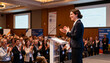 © Peter - Professional female speaker at a business conference receiving applause from the audience. Successful public speaking event. Corporate seminar presentation with a happy crowd clapping.