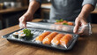 © Valena - Packaged sushi rolls and nigiri on a tray wrapped in clear film for freshness and convenience