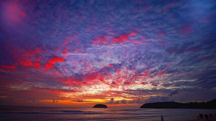 Wall Mural - Time lapse Island Glow at Kata Beach Phuket. The last rays of sunshine illuminate the clouds with vibrant colors, blending seamlessly with the turquoise waters, a perfect moment of peace and wonder.