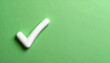 © Hafidzul - A simple white check mark placed on a textured green backdrop, offering a clean and uplifting visual suited for themes of success, acceptance, or confirmation.