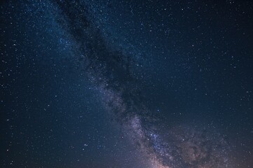Wall Mural - Night sky filled with stars and cosmic dust in the vast universe, long exposure capture with grainy texture