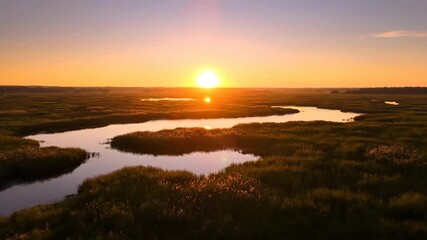 Wall Mural - Golden sunrise illuminates a vast marsh, showcasing the dawn's shifting colors in a breathtaking timelapse golden hour, vibrant, clouds