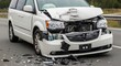 © uceeef - Front end collision damage on a white minivan showing crumpled hood and broken bumper