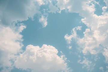 Wall Mural - Bright daytime sky filled with fluffy white clouds against a clear blue backdrop