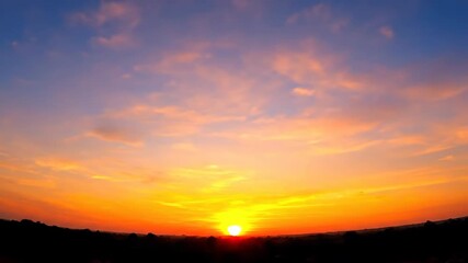 Wall Mural - dynamic wide shot capturing the rapid shift of colors in the sky as the sun dramatically rises above