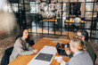© Maskot - High angle view of happy woman giving interview to business professionals while sitting at table in office