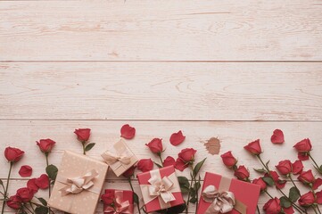 Wall Mural - Roses and gift packages arranged on a pale wooden surface with room for writing. Romantic holiday theme