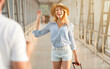 © Prostock-studio - Husband meeting wife at airport terminal, welcoming back home. Woman waving hand to man