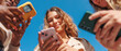 © Alberto - Diverse women holding smartphones, engaging in social media and digital connection under a blue sky