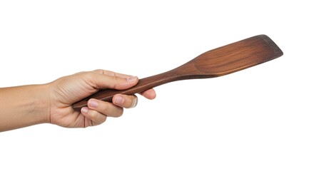Hand holding a wooden spatula with brown hues isolated against a white backdrop