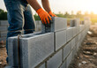 © Mahmuda - A construction worker is building a sturdy and reliable concrete block wall structure