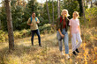 © BGStock72 - Family enjoys a happy hike through a sunny forest in early autumn with tall trees and vibrant foliage