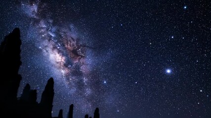 Wall Mural - a dense starfield glides majestically across the night sky above ancient, silhouetted ruins meditati