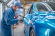 © kuchina - A professional painter carefully applies a fresh coat of vibrant blue paint to a car in a modern automotive factory, ensuring a flawless finish with meticulous attention to detail.