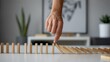 © Kolpona - Finger Pushing Dominoes to Start Chain Reaction