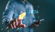 © Looker_Studio - Businessman launching startup rocket icon toward 2026 target, representing business growth, innovation, future strategy, goal achievement, and success planning in digital transformation.