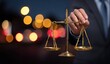 © rudy - Hand holding justice scale with bokeh background for legal representation