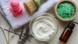 © Naila - A spa setting with a bowl of cream, bath salts, essential oil, and other spa accessories on a table