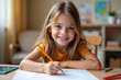 © Thanawadee - Happy Little Girl Smiling While Drawing and Coloring at a Table
