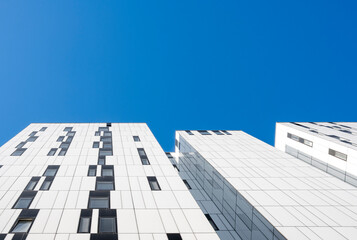 White modern facades with clean vertical geometry and blue sky, clarity and background designed for corporate branding and editorial layouts