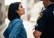 © Vasiliy - Civilian woman talking with a police officer on the street. Law enforcement and public interaction. Community safety and authority concept