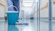 © twc - Floor cleaning in a pristine setting.  Mop and bucket ready for action, ensuring cleanliness and hygiene. Reflections gleam on the freshly mopped surface.