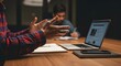© Mono - Two people working at a table with a laptop and notebook.