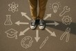 © Jelena - Teen choosing career path standing on chalk arrows crossroads top view decision concept