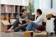 © itchaznong - Sharing Moments. Couple enjoying water break while unpacking boxes.