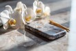 © jiyacreatives - Elegant marble phone case with gold accents and delicate white orchids on a sunlit marble surface, exuding luxury and sophistication