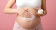 © helga - Pregnant woman applying cream on her belly to prevent stretch marks, promoting healthy pregnancy and skincare with soft touch and care