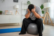 © Kawee - Exhausted Asian plus-size man taking a break while workout in house.