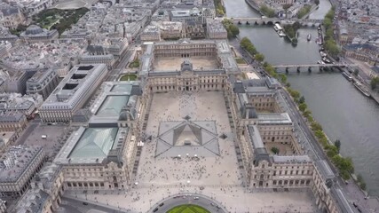 Wall Mural - Aerial drone view descending over the Louvre with Pyramid, Tuileries Garden, Seine River and Place du Carrousel surrounded by the historic Parisian skyline.