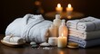 © Gurih - Spa relaxation setting towels robe candles and products on wooden surface