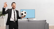 © Ljupco Smokovski - Man in a black suit and tie at home holding a soccer ball and gesturing ok sign