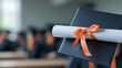 © Rafa Fernandez - Graduation cap and diploma with orange ribbon, close-up