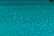 © shine.graphics - Close-up of shimmering turquoise pool water with gentle ripples and reflections.