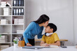© Phimwilai - Asian mother kissing son on forehead while studying at home