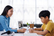 © Phimwilai - Asian teacher helping young student with homework at home