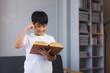 © Phimwilai - Smart asian kid enjoying reading a book at home