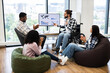 © sofiko14 - Group of diverse colleagues discussing and applauding presentation on business progress. Image features young professionals in casual workspace, including individual in wheelchair and ethnic diversity