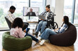 © sofiko14 - Group of young diverse professionals including men and women meeting, using technology, engaging in video conferencing showing dedication, inclusion, modern workplace values