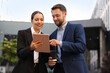 Coffee to go. Man with paper cup of drink and his business partner during meeting outdoors