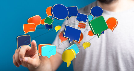 Conceptual shot of a man interacting with virtual speech bubbles, symbolizing communication, networking, and social media engagement. 142 chars