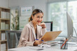 © Crystal - Smiling businesswoman working with documents at office desk