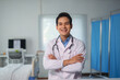 © Crystal - Portrait of smiling doctor standing in hospital room with arms crossed