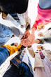 © Xavier Lorenzo - Bottom view of united young group of diverse people standing in circle joining hands showing support and cooperation. Youth community and teamwork concept with student friends stacking hands.