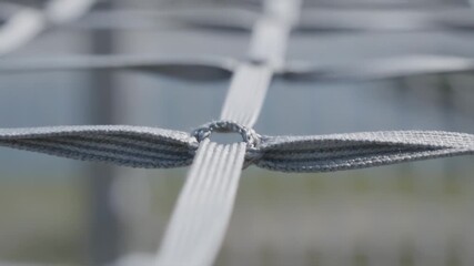 Detailed view of woven grey netting, strong connecting knot structure.